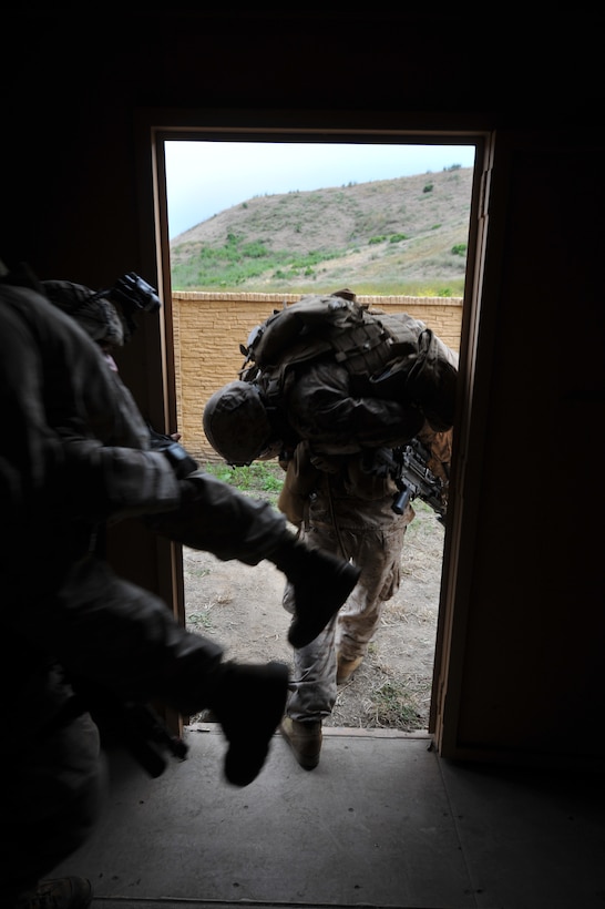 Marines with India Company, Battalion Landing Team 3/1, the 11th Marine Expeditionary Unit’s ground combat element, carry fellow Marines with simulated injuries to a CH-46E helicopter after conducting a helicopter raid on an urban training environment here June 16. The Marines are training for their deployment later this year.